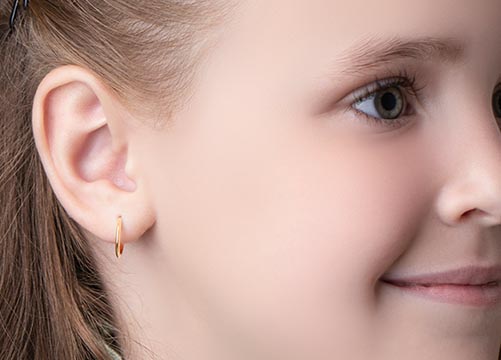 Creolen f&uuml;r Kinder &ndash; Nahaufnahme goldener Kinder-Creolen mit Diamanten