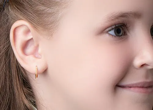 Creolen f&uuml;r Kinder &ndash; Nahaufnahme goldener Kinder-Creolen mit Diamanten